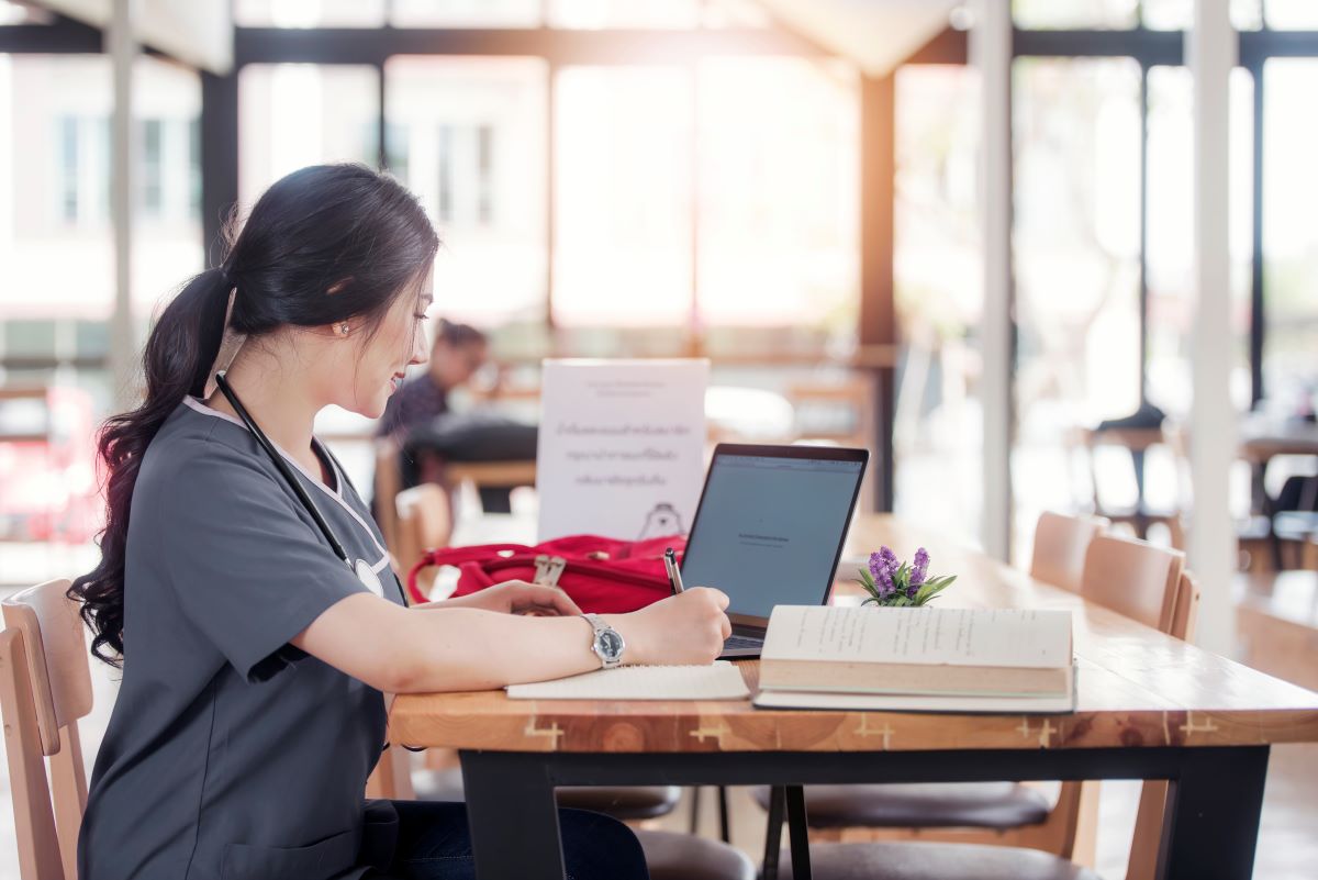 nurse-at-table-with-computer-and-books