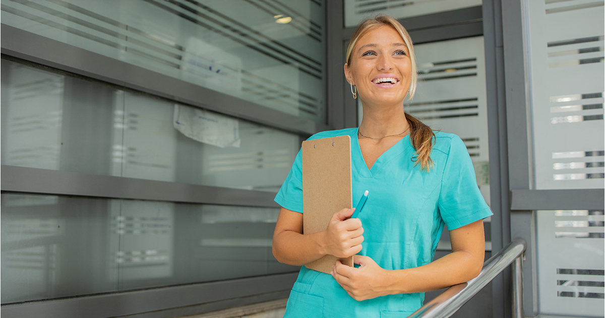 a nurse smiling holding a clipboard
